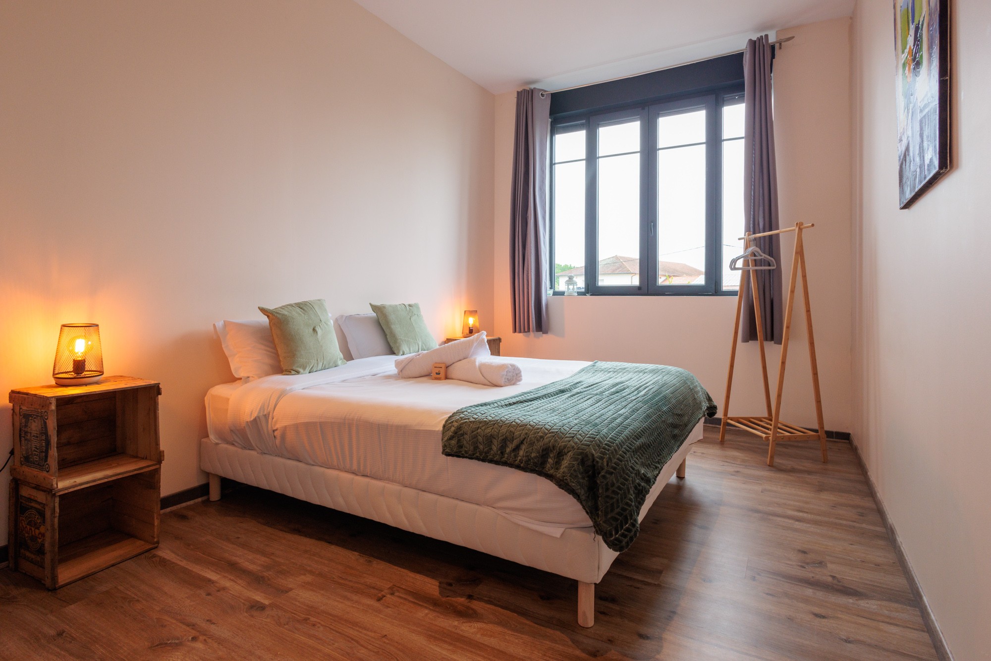 Chambre de gîte avec plaid sur le lit et ambiance cosy chaleureuse.